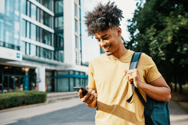 istock African American man with braided hair  using smart phone while in downtown 1387960397