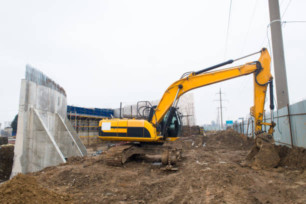 istock Broken crawler excavator at construction site near concrete wall 1387967333