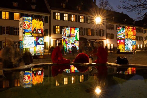 Basel carnival 2021 during COVID-19 pandemic Basel, Switzerland - February 23, 2021. Carnival revellers in red costumes at the fountain on the cathedral square fastnacht stock pictures, royalty-free photos & images