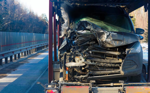 istock Crashed car after the accident. Trailer transporting wrecked car on  highway 1387968130