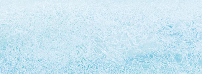 Natural ice panoramic background. Texture frozen natural blue ice crystals, top view. Ice patterns on the water surface winter
