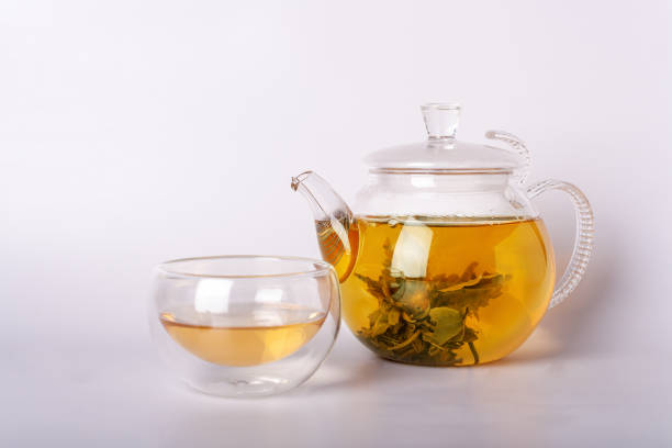 istock green tea in glass cup and teapot on white background 1387969561
