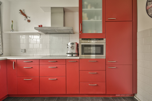 Small kitchen with red furniture and tiled floor in a modern house