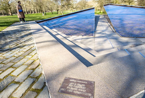 A woman observing Canada Memorial in Green Park in City of Westminster, London. It was designed by the Canadian sculptor Pierre Granche and completed in 1992.