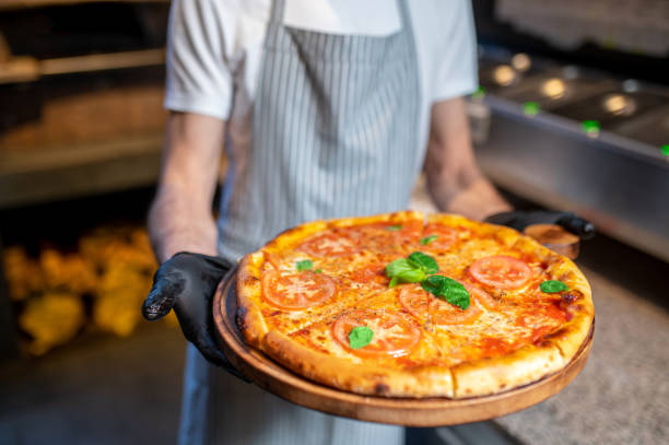 istock A chef holding a big pizza in his hands 1387978476
