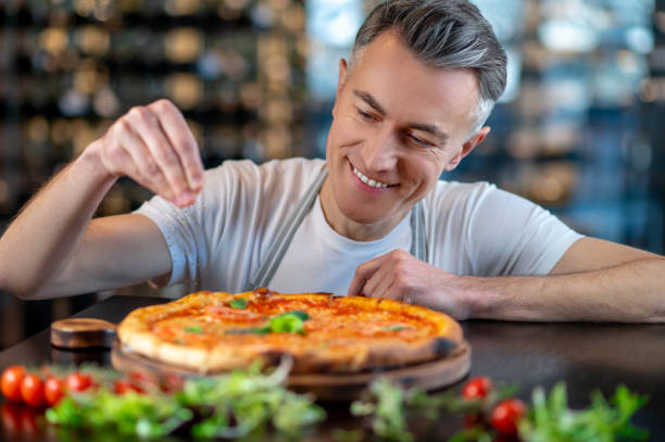 istock A chef making topping on a italian pizza 1387978491