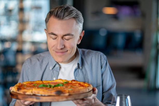 istock A man sitting in a cafe and getting ready for eating a delicious pizza 1387978509