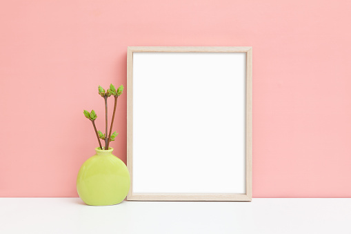 Mockup of a thin wooden frame. A stylized image of a thin vertical frame on a table. Minimalistic frame mock-up.