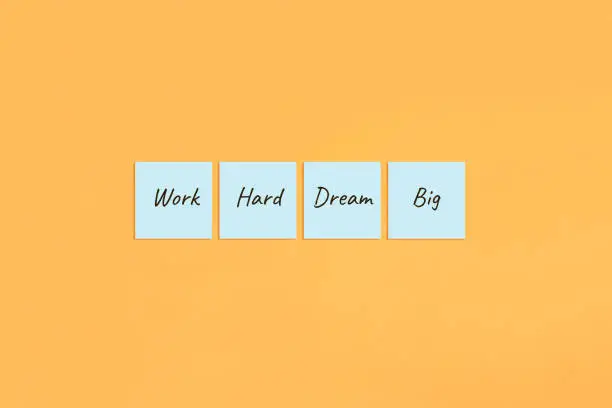 Motivational saying Work hard dream big. Handwritten inscription on sticky notes.