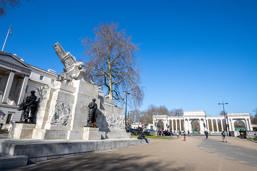 Royal Artillery Memorial in Hyde Park Corner, London. This memorial dedicated to the nearly 50,000 soldiers from the Royal Artillery killed in World War 1, was designed by Charles Sargeant Jagger and was revealed in 1925. People and a double decker bus can be seen in the background.