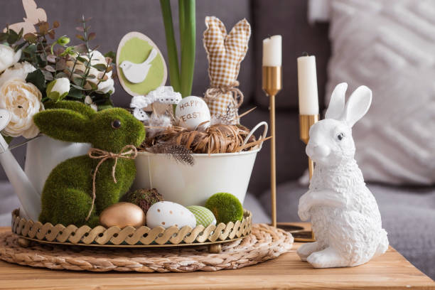 istock Rustic. White-green colors. Iron planters with Easter eggs, flowers, candles and rabbits in the living room interior on the table. The concept of home comfort in the bright holiday of Easter 2022. 1387983715