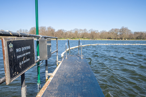 No Diving Sign on The Serpentine Lido at Hyde Park in City of Westminster, London, with the royal seal visible.