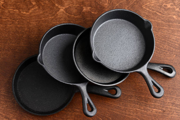 istock pile of cast iron skillets on wood table 1387985251