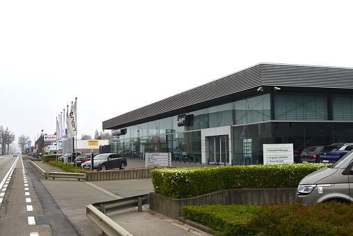 Boortmeerbeek, Vlaams-Brabant, Belgium - March 27, 2022: luxury official Audi dealer building and parking at main road connecting city of Leuven direction Mechelen city