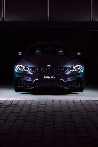The front of the BMW M3 30 Jahre Edition standing in a dark garage. Limited edition created to celebrate the 30th anniversary of the M3. 500 pcs only, 450 hp. Katowice, Poland,  12.03.2016 The front of the BMW M3 30 Jahre Edition standing in a dark garage. Limited edition created to celebrate the 30th anniversary of the M3. 500 pcs only, 450 hp. Katowice, Poland,  12.03.2016 bmw stock pictures, royalty-free photos & images