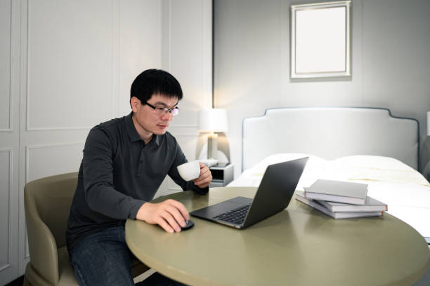 istock A middle-aged Asian white-collar man works from home using a laptop for online video conferencing 1387989286