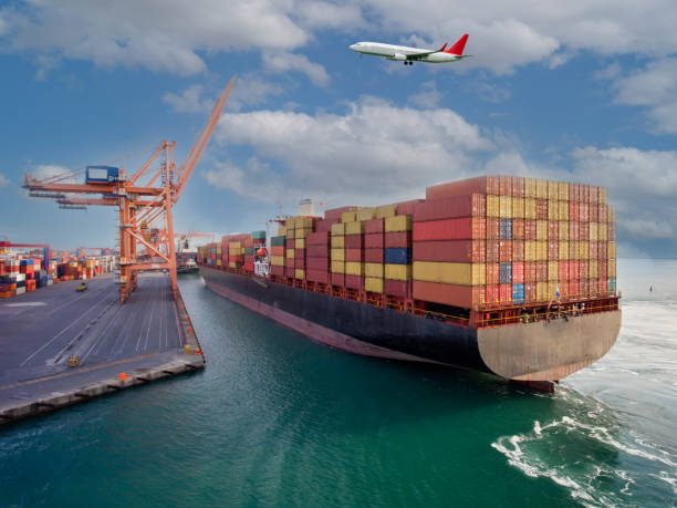 istock Airplane flying over international port. 1387991143