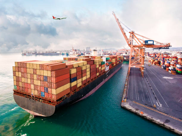 istock Airplane flying over international port. 1387991651