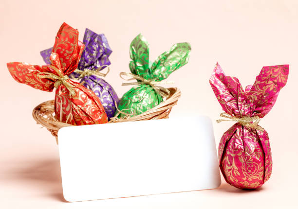 Easter Egg Basket filled to the Brim With eggs and chocolates for the Easter holiday, hand woven bamboo basket with stunning textures on a reflective surface with a perfect mirror image.