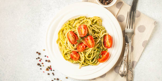istock Paste with tomatoes and spinach sauce in a plate on a table. Selective focus. Copy space. Top view 1388003151