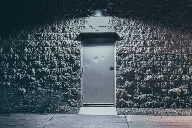жуткая дверь ночью со светом - street alley dark city стоковые фото и изображения