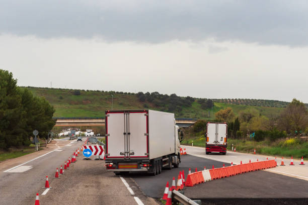 istock Refrigerated trucks changing lanes on a highway closed for works. 1388004057