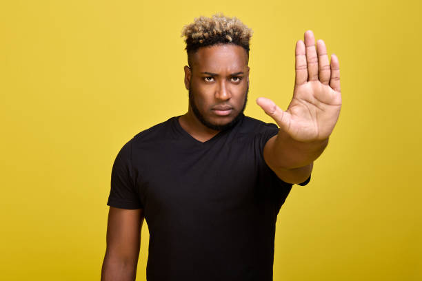 istock Stop there is no road - guy shows with stopping hand gesture with serious look 1388005784