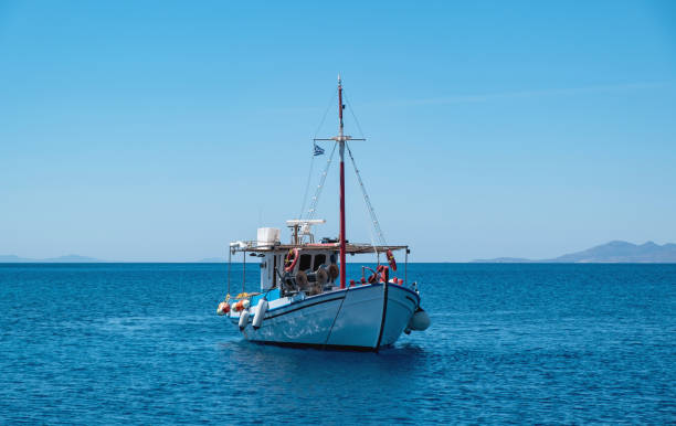 hölzernes fischerboot in der ägäis vor anker, blauer himmelshintergrund. koufonisi griechische insel, kykladen. - kutter stock-fotos und bilder