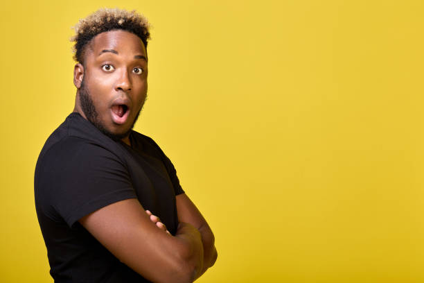 istock Handsome young man stands sideways with worried and surprised expression 1388006847