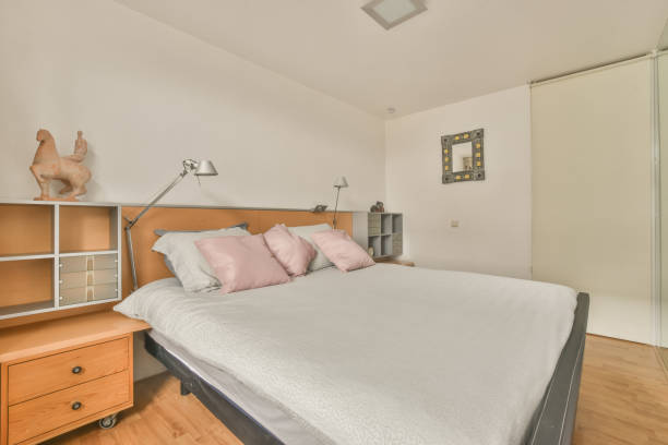 istock Cozy bedroom design with a large white bed 1388006964