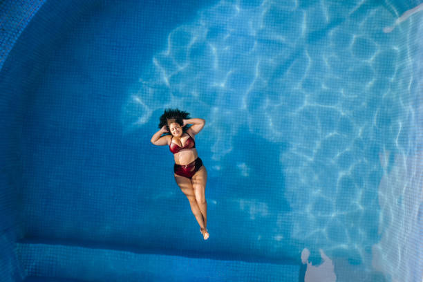istock Woman floating in the pool 1388009269