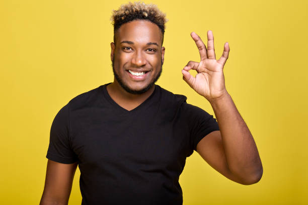 istock Dark-skinned smiling man makes a sign ok with his fingers 1388009802