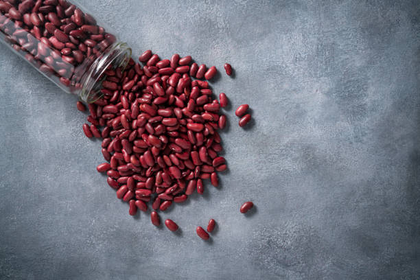 istock Red Beans dried legumes on a glass jar spread on gray stone background copy space 1388010598