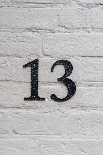 istock White brick wall with a number thirteen in black 1388011017