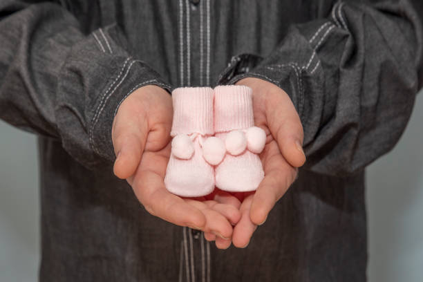 dad holding a pair of newborn baby booties
