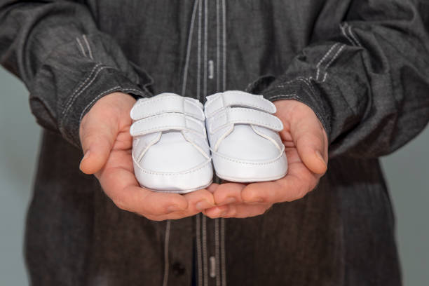 dad holding a pair of baby shoes