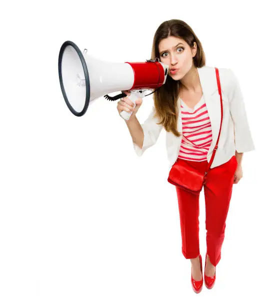 Photo of Shot of a young woman using a megaphone against a studio background