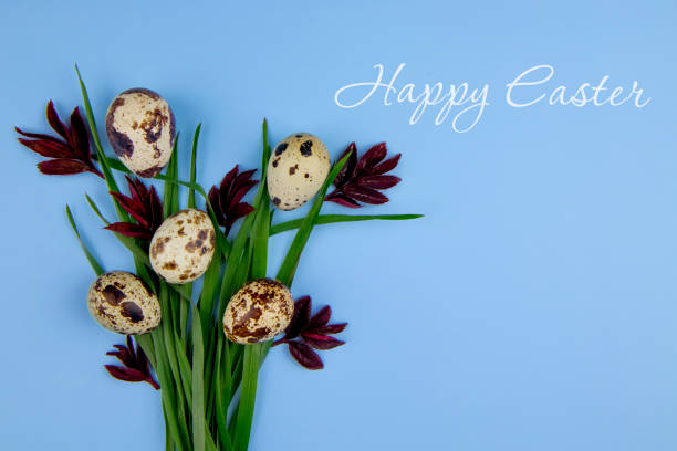istock Easter bouquet of green grass and quail eggs on a blue background. View from above. Easter composition in the style of minimalism. Copy space. Greeting card. 1388017434