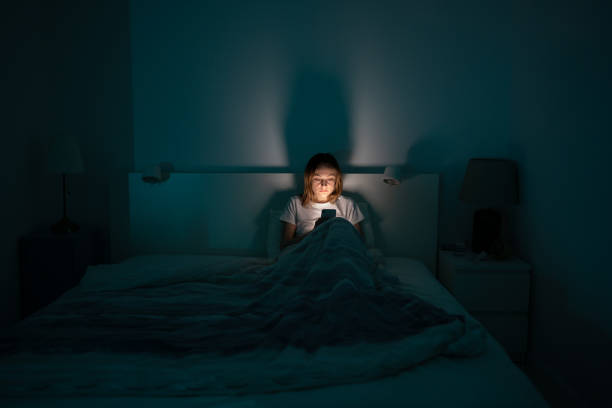 sleepy woman lying in bed using smartphone late at night, can not sleep. insomnia, addiction concept - insomnia imagens e fotografias de stock