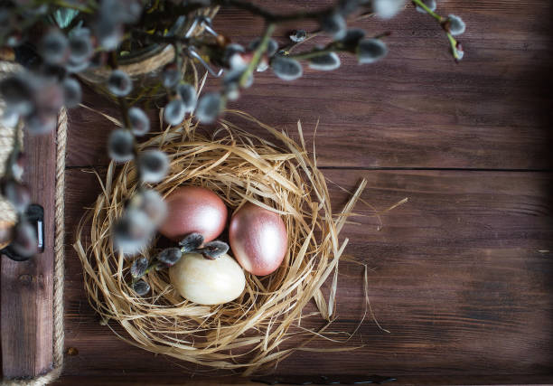 istock Pink and yellow Easter eggs in nest on wooden background.  Minimal easter concept. Easter card with copy space for text. 1388018669