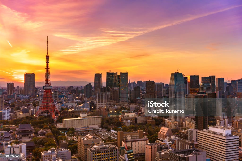 Bird's-eye view of a beautiful pink and orange color sunset on the iconic Tokyo tower with no logo. tokyo, japan - march 23 2022: Bird's-eye view of a beautiful pink and orange color sunset on a cityscape of the Shibadaimon district overlooked by the iconic Tokyo tower. City Stock Photo