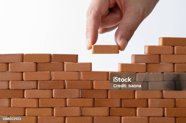 Man Putting Toy Brick Onto A Wall Stock Photo - Download Image Now - Toy Block, Brick, Building - Activity