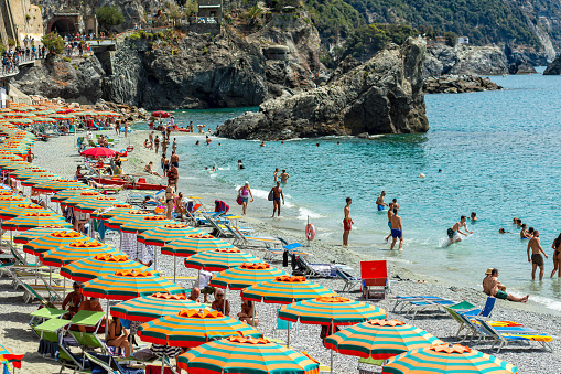 Cinque Terre, famous Italian Riviera coast with blue Mediterranean Sea, Colorful beach umbrellas