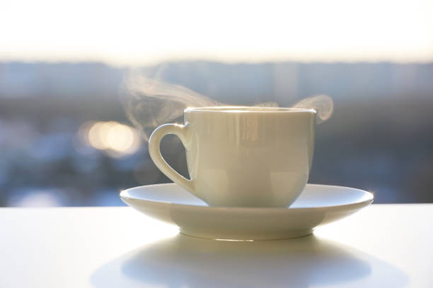 istock Hot coffee or tea cup with steam smoke on shining sun background 1388026511
