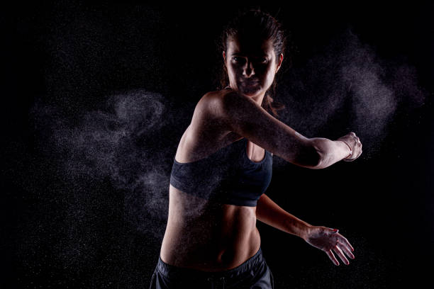 istock Kickboxer kirl with magnesium powder on her hands, punching with dust visible. 1388026564