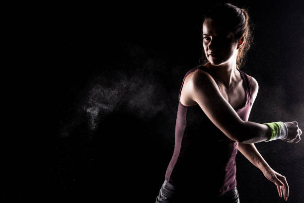 istock Kickboxer kirl with magnesium powder on her hands, punching with dust visible. 1388026599