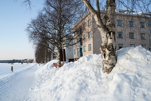 A typical winter scene of a snowy street on the bank of frozen Kemijoki river, Rovaniemi, Finland