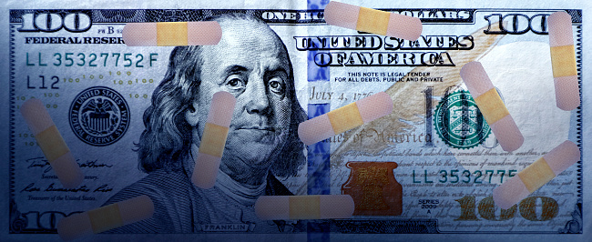 Close up one hundred dollar bill with adhesive bandage