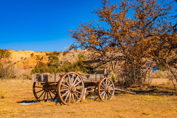 old wooden cart on the western landscape of New Mexico old wooden cart on Ghost Ranch on the western landscape of New Mexico wagon wheel bench stock pictures, royalty-free photos & images