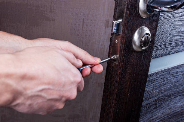 istock The carpenter with a screwdriver installs and adjusts the door lock 1388032701